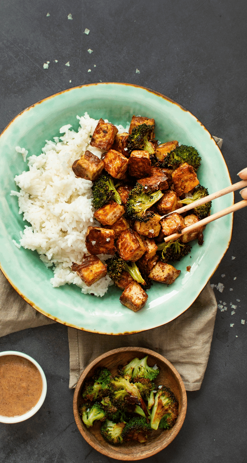 Mandelmarinerad tofu med ris och broccoli i en ljusblå tallrik