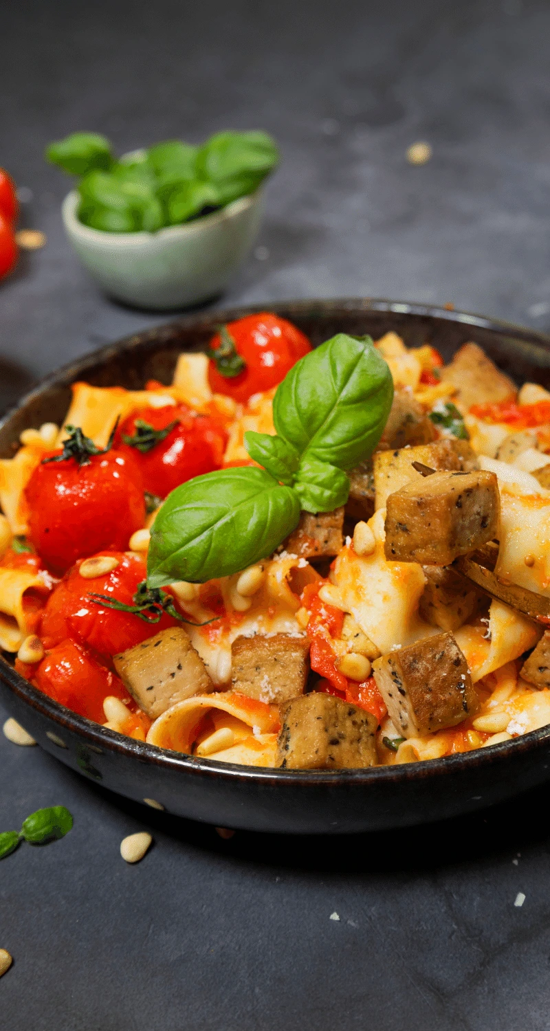 Bilden visar en pasta med tofu och tomatsås.