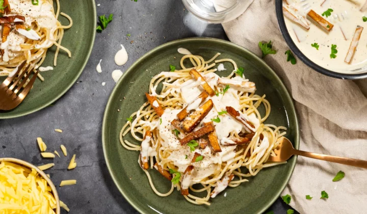 Vegansk pasta med "skinksås", spaghetti på en tallrik med sås och rökt tofu som skinka, perfekt till vegetariska matlådor